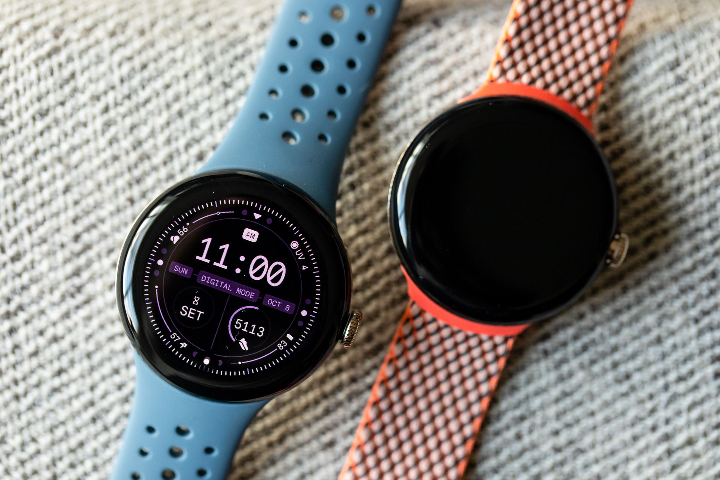 The Pixel Watch 2 with its screen on, next to the original Pixel Watch with its screen off.