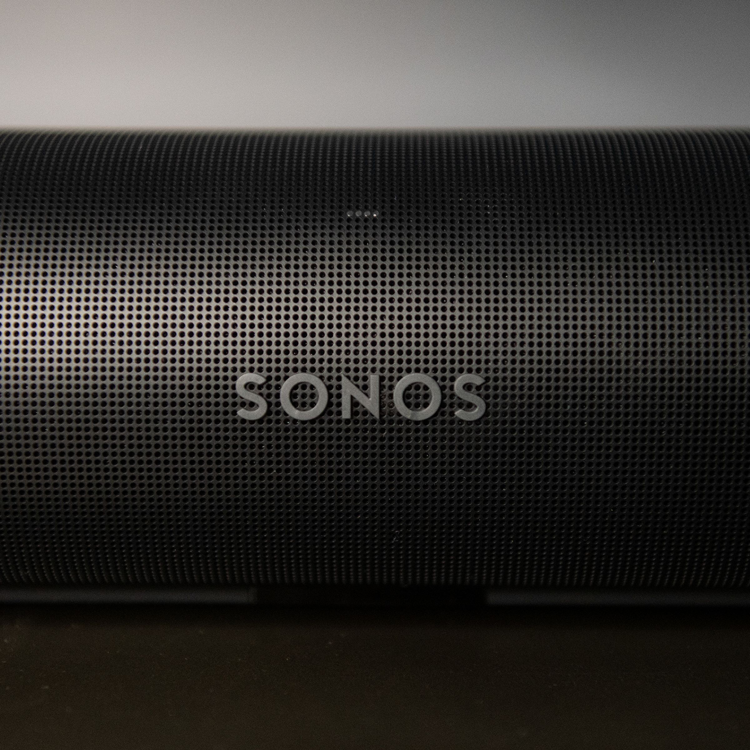 A detail shot of the front of the Sonos Arc, showing the Sonos logo and many perforated holes in the outer casing.