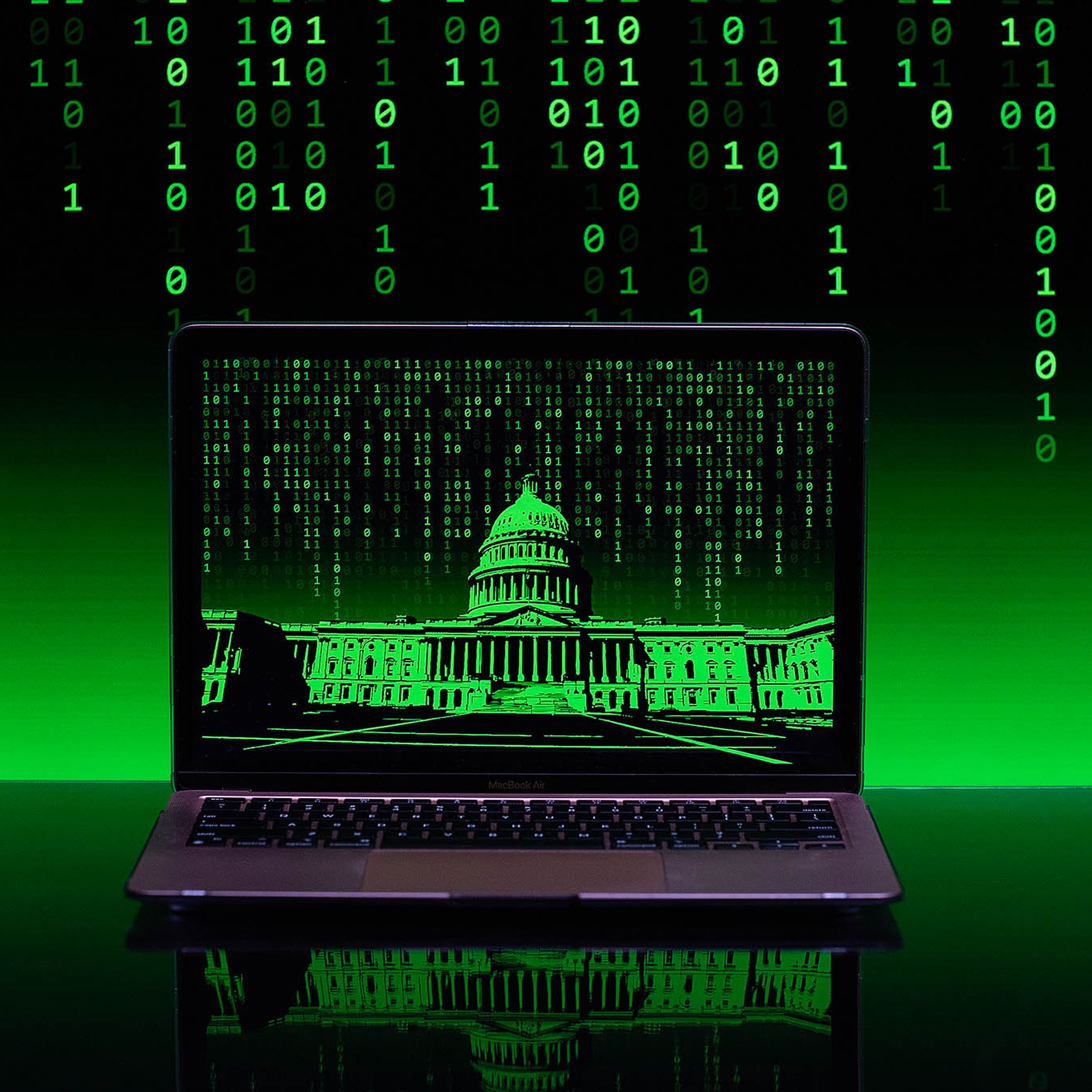 A matrix of green binary code flows down in the background of a laptop computer with a green-hued image of the US Capitol building