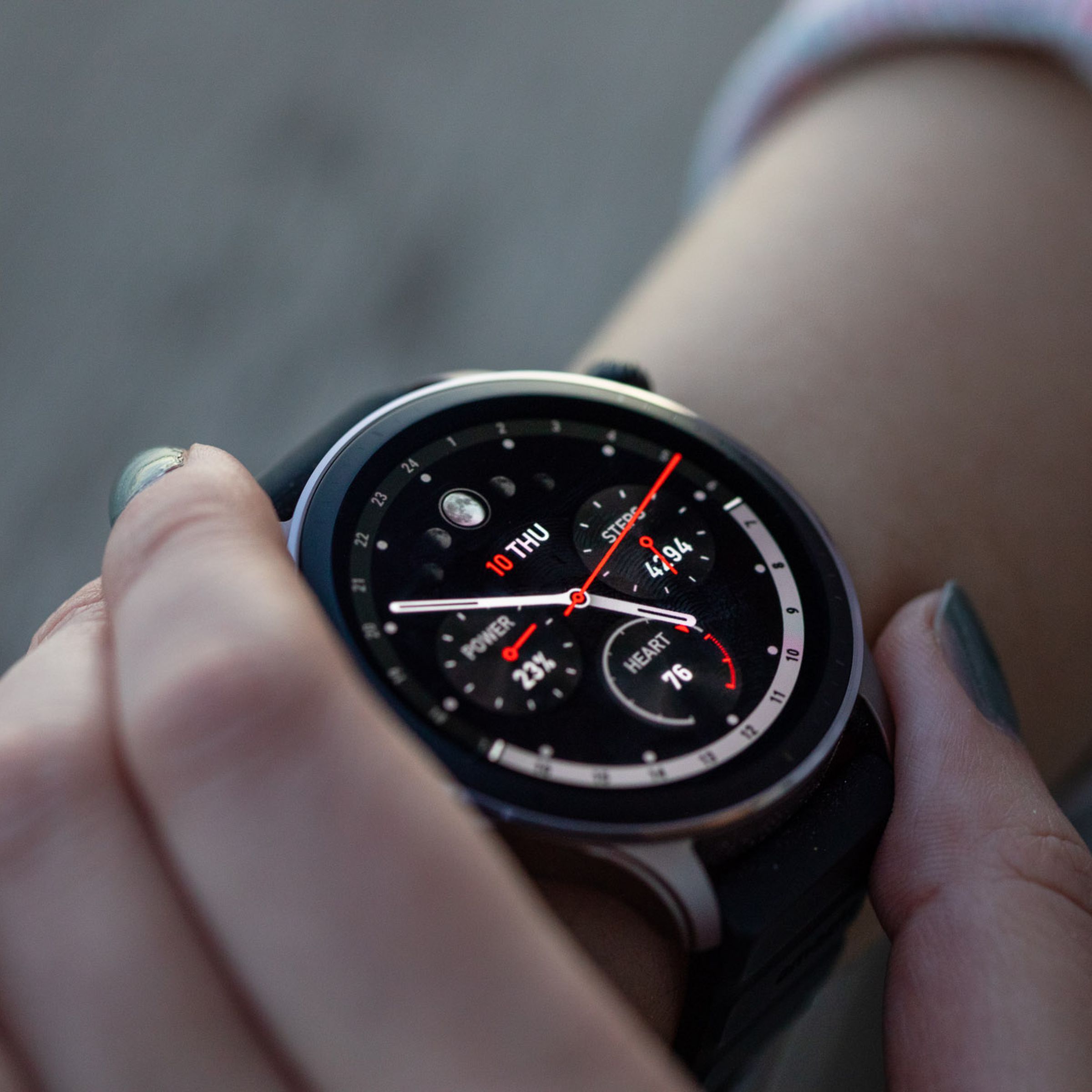 Amazfit GTR 4 on a woman’s wrist with a closeup of an analog watch face