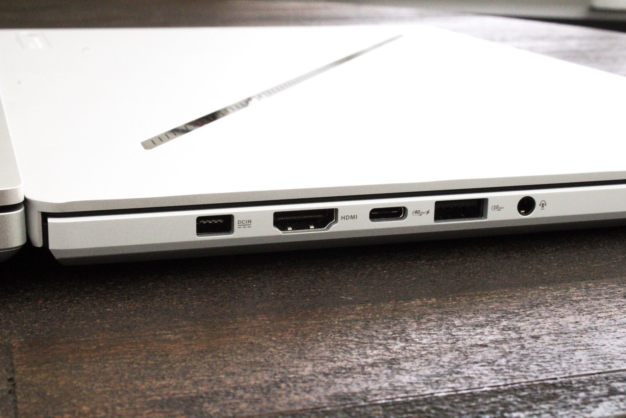 A close-up of a few connectivity ports on the side of a white laptop.