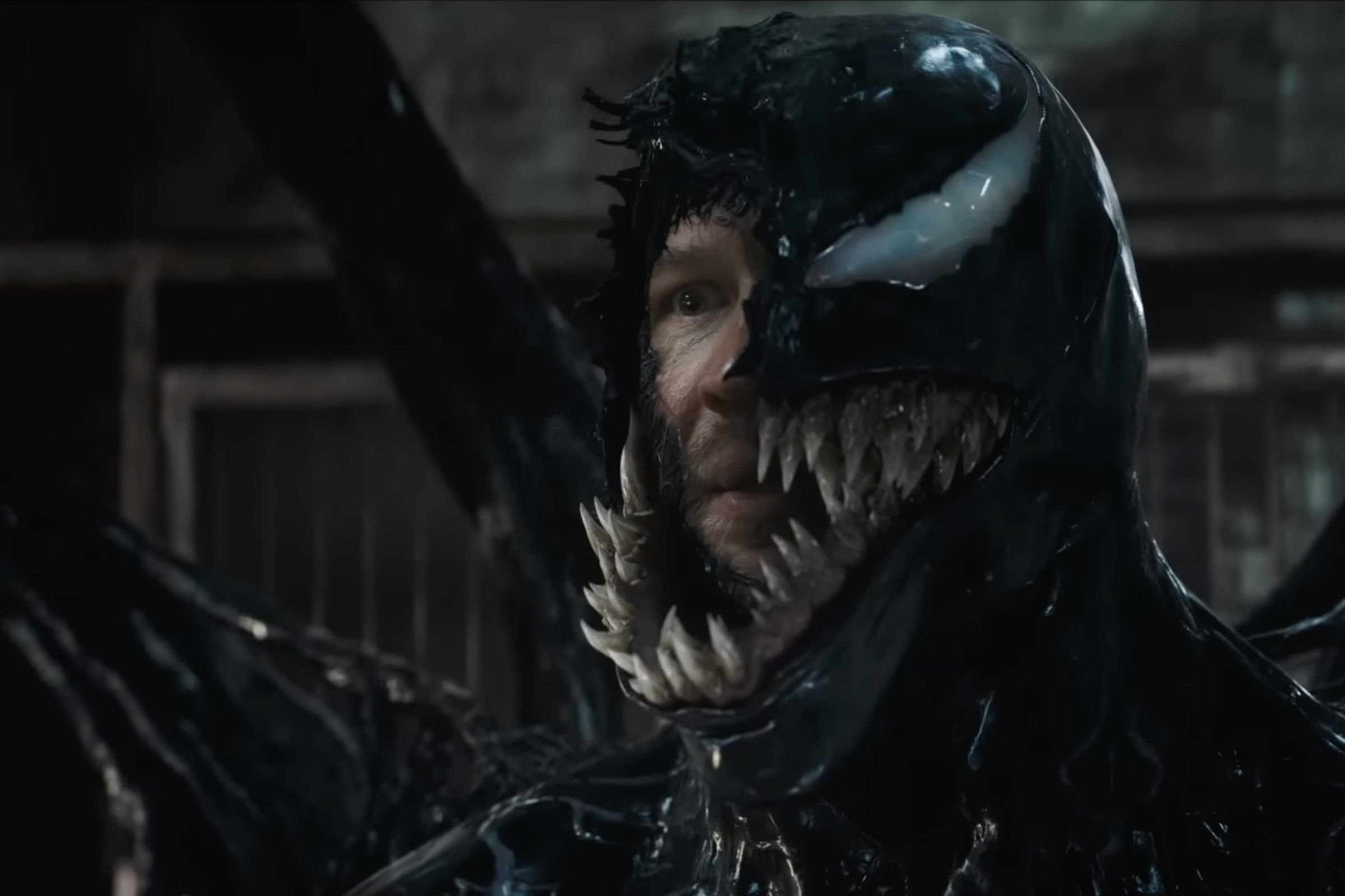 Picture of Venom with part of his mask removed, exposing Eddie Brock’s face.