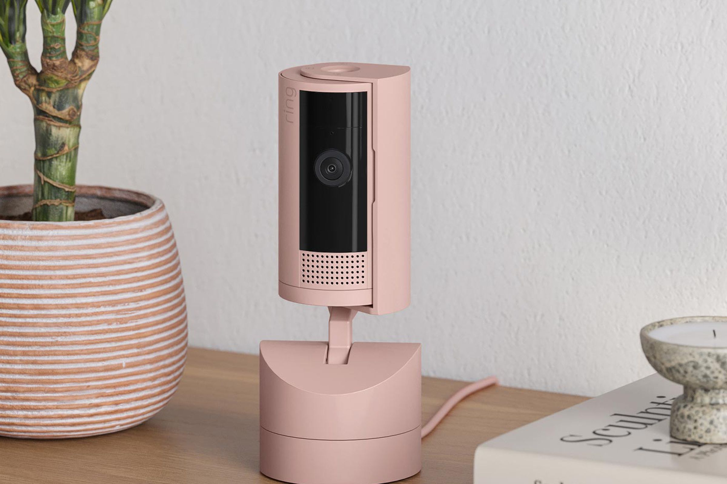 A pink security camera on a table.