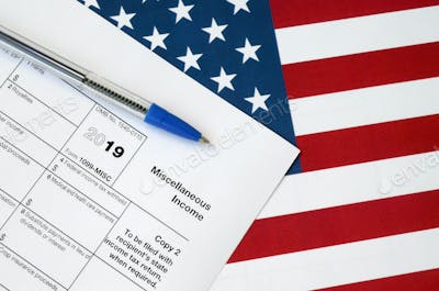 Form 1099-misc Miscellaneous income and blue pen on United States flag