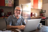 older man laptop smiling GettyImages-1278322389