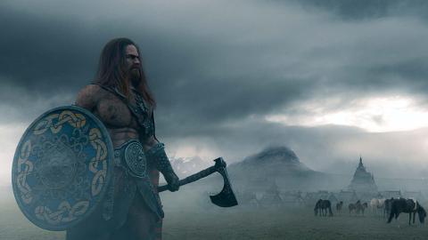 Viking warrior holding an ax and a shied on a foggy landscape