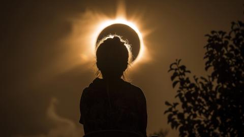 Silhouette of a person looking at a solar eclipse