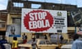 People walk past a billboard with a message about ebola in Freetown, on November 7, 2014. West Africa's regional bloc on November 7 called for international help to go beyond immediate medical care for Ebola-hit nations, warning that lives had been blighted by the epidemic. AFP PHOTO/ FRANCISCO LEONGFRANCISCO LEONG/AFP/Getty Images
