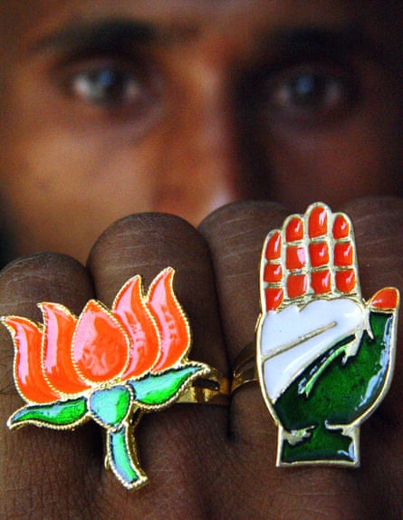 A shopkeeper displays rings with BJP and Indian National Congress party symbols.