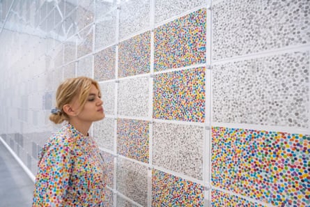 A staff member at the preview of The Currency by Damien Hirst, a work comprising 10,000 similar but unique large banknote-style paintings which Hirst imagined could be used as a form of handmade currency in either a digital (NFT, non-fungible token) or physical form.