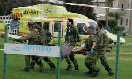 Israeli soldiers carry a wounded soldier at Soroka hospital in Beersheba