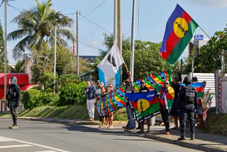 People demonstrate as French president Emmanuel Macron’s motorcade drives past in Nouméa.