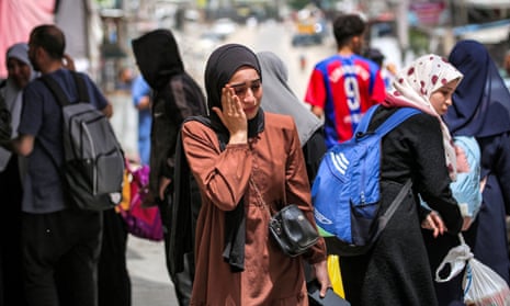 A woman waits with others before evacuating from Rafah in the southern Gaza Strip.