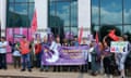 Protest outside the annual shareholder meeting:a group of people hold union flags, banners and signs including one calling for a living wage.