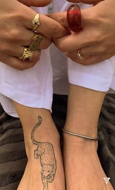 two people with matching tattoos on their feet, one holding the other's hand