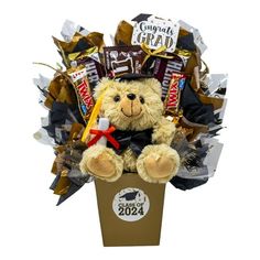 Commemorate your grad's accomplishments with this delightful graduation gift bouquet. Sitting a top is a keepsake graduation teddy bear sporting a gown, hat with tassel and holding a diploma in its paw, surrounded by sweet treats. Graduation Gift Arrangement includes Plush graduation teddy bear Congrats Grad Wand Fun Sized Twix Hershey with Almonds M&M's Decorated with tissue and fun graduation cellophane all arranged in a box with the graduating year on the front. Honor their extraordinary achievement with this plush teddy bear graduation gift bouquet. Color: Blue.