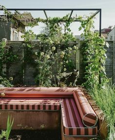 an outdoor hot tub in the middle of a garden with plants growing on it's sides