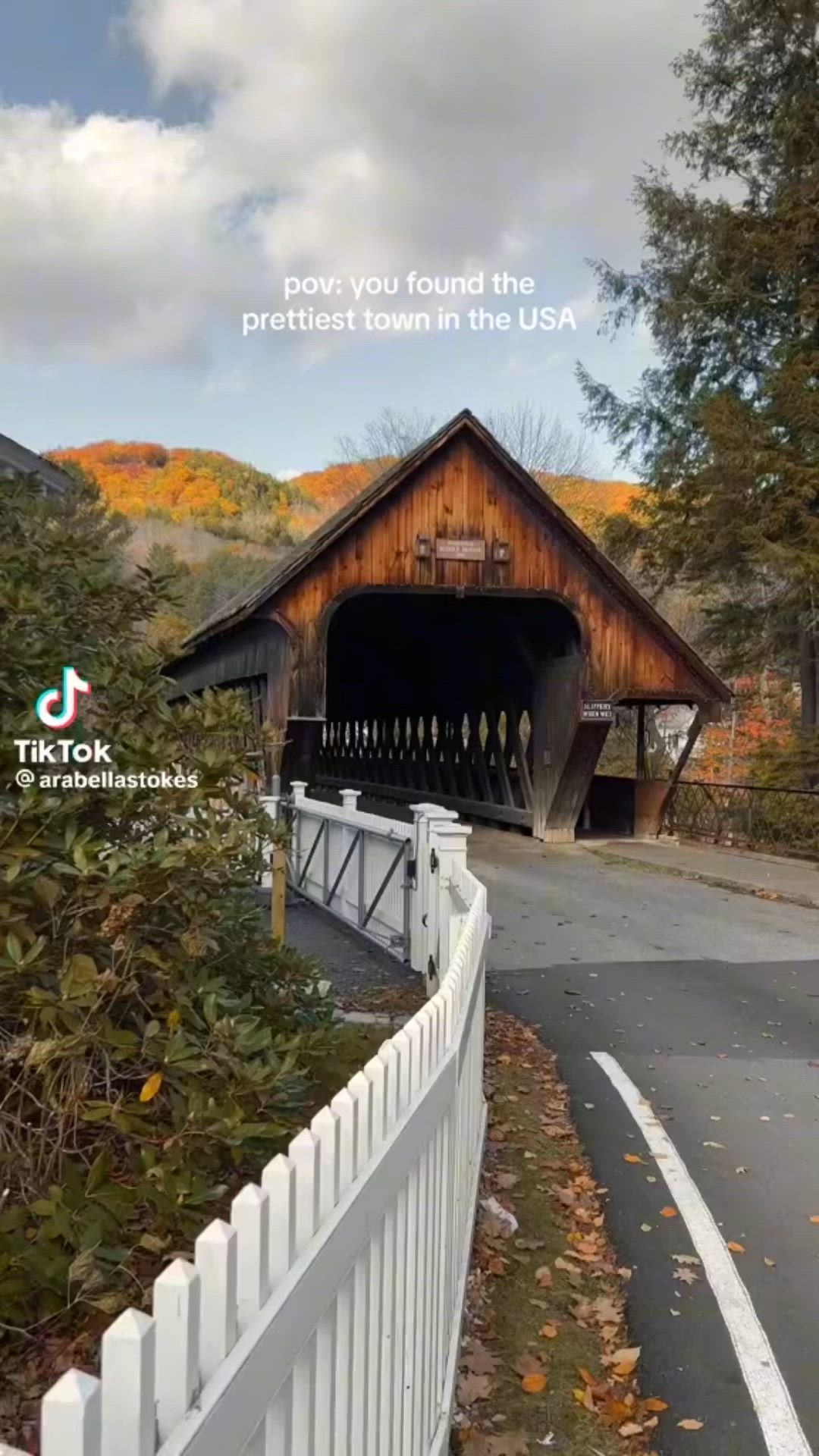 This may contain: an image of a covered bridge in the fall with text over it that reads, pov you found the prettiest town in the usa