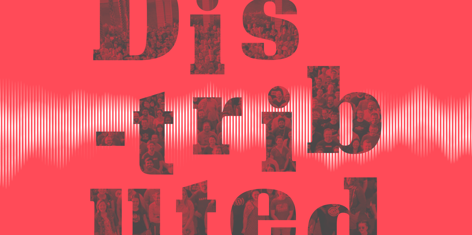 A graphic image of the word Distributed that is overlayed on top of an image of Automattic employees at a company meetup. The text is placed over a red background.