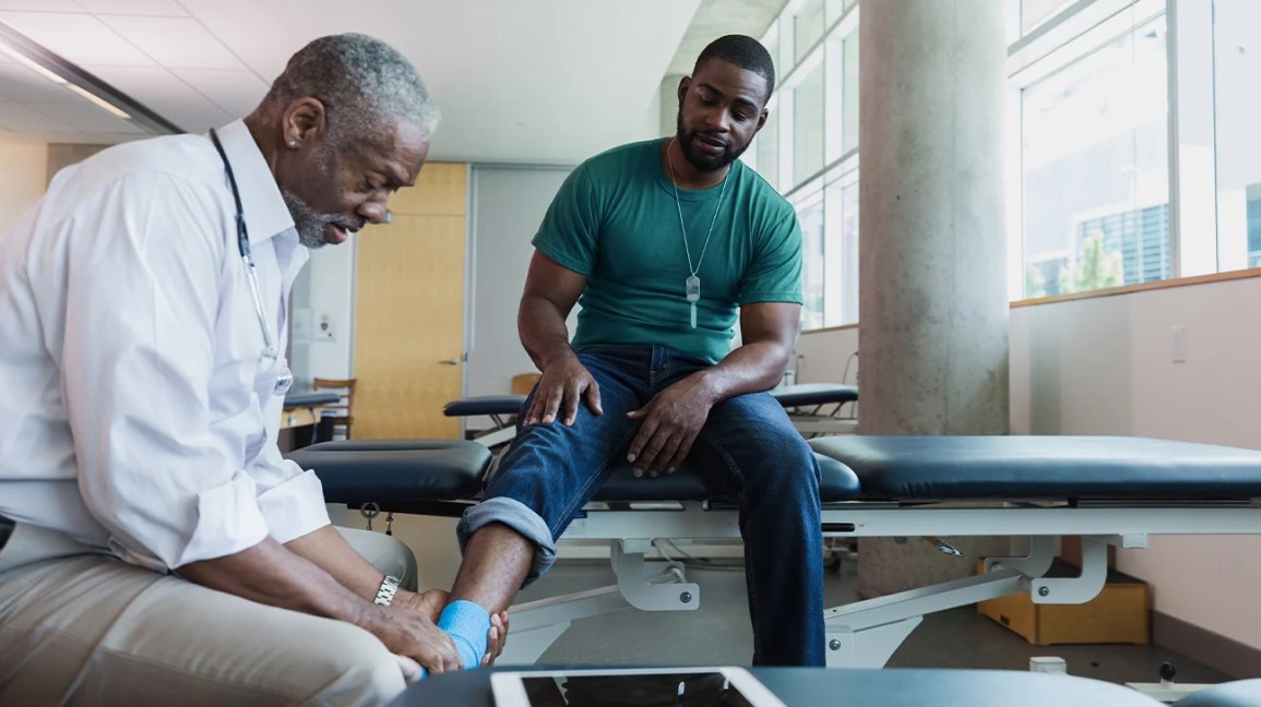 An orthopedic doctor examines the ankle movement of a patient. 