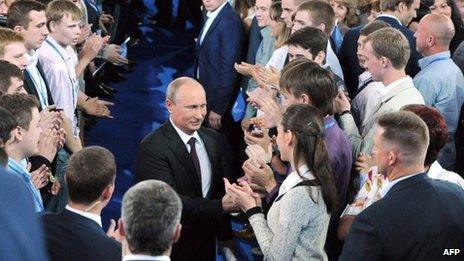 Russian President Vladimir Putin greets supporters as he arrives at the founding congress of a movement called the All-Russia Popular Front