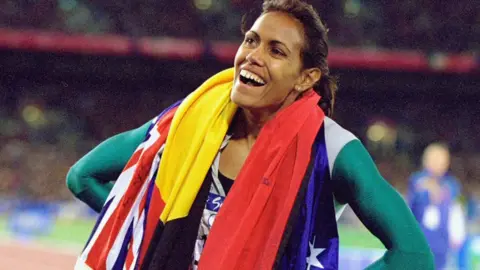 Getty Images Cathy Freeman wearing the Aboriginal and Australian flags after her win at the Olympics in 2000