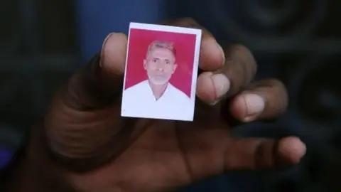 AFP A relative holds a photograph of slain Indian villager Mohammad Akhlaq at his home in the village of Bisada,