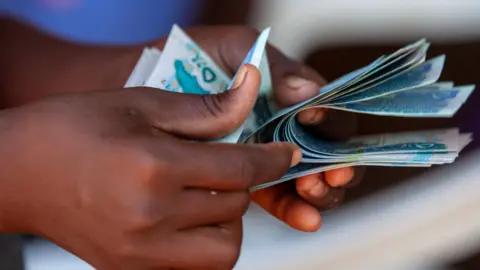 Getty Images A person counting Somalian shillings