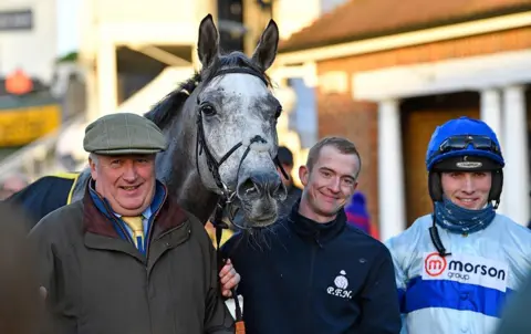 Tracy Roberts  Kirkby (centre) pictured with trainer Paul Nicholls (left) and jockey Harry Cobden (right)