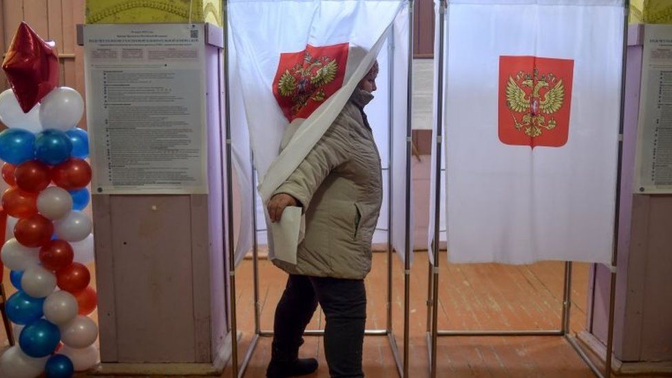 A woman comes out of a polling station