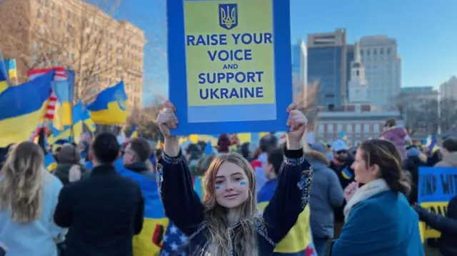 「声を上げてウクライナを支援して」と書かれたプラカードを掲げるロイエクさん