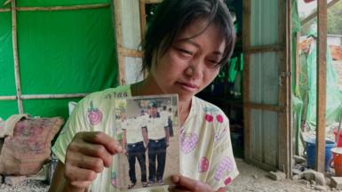 Mother Molly Khiang holds a photo of her son