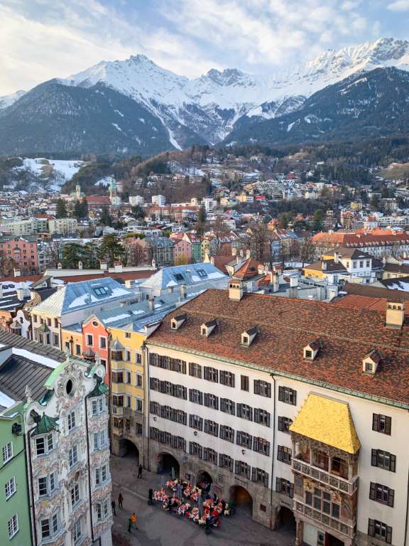 Blick auf den belebten Wohnraum in Innsbruck mit historischen Gebäuden vor der alpinen Bergkulisse