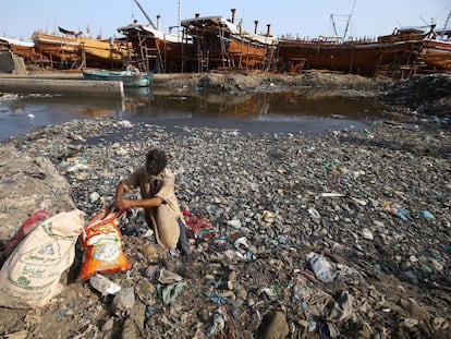 Un hombre busca elementos reciclables entre montones de basura y plástico el mismo día que se celebra el Día Mundial del Medio Ambiente, en Karachi, Pakistán.