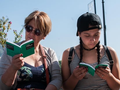 Dos mujeres leen una recopilación de cuentos inscritos al concurso.