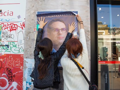 Dos mujeres pegan un cartel de Pello Otxandiano en la parte vieja de San Sebastián.