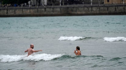 Dos aguerridos bañistas en la playa de San Lorenzo de Gijón, este domingo.