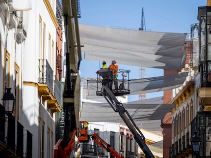 Operarios trabajan en el centro de Sevilla. FOTO: PACO PUENTES (EL PAÍS).