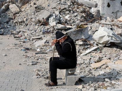 Un hombre palestino permanece sentado junto a los escombros de una casa destruida por un ataque israelí en Rafah, al sur de Gaza, el pasado martes.