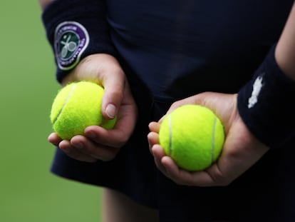 Una recogepelotas de Wimbledon sostiene dos bolas durante un partido.