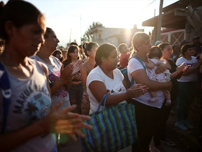 Familias esperan para recibir una bolsa de comida de caridad, en Villa Fiorito, Argentina, 27 de febrero.