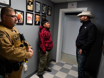 Autoridades del condado de Terrell hablan con un migrante detenido, el 21 de marzo 2024 en Sanderson, Texas.