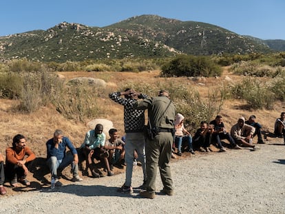 Un agente de la Patrulla Fronteriza de EE UU inspecciona a un migrante solicitante de asilo en Barrett Junction (California), el 5 de junio.