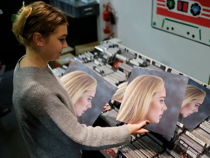 Empleada de una tienda del Soho londinense, con el disco ‘30′, de Adele.
