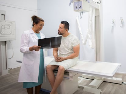 Doctora revisa una radiografía con un paciente.
