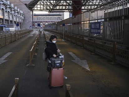 Una mujer en el estacionamiento para taxis vacío de una estación de tren en el oeste de Pekín. 