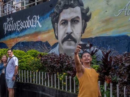 Varios turistas recorren las calles del barrio Pablo Escobar y se hacen fotos con los murales, en Medellín, Colombia, el 21 de noviembre de 2023.