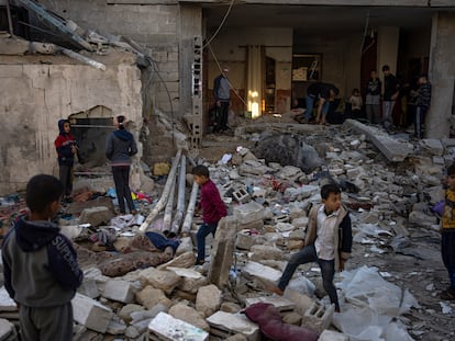 Palestinians look at the destruction after an Israeli strike in Rafah, southern Gaza Strip, Friday, Dec. 29, 2023.