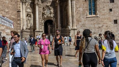 Turistas en la plaza de la Reina de Valencia, con la catedral de la ciudad al fondo.