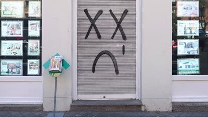 Oficina inmobiliaria de Madrid con un grafiti en su cierre.